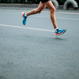 A runner's feet running on a road