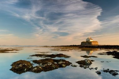 This image shows St Cwyfan's Church, commonly known as the "Church in the Sea," located on the tiny island of Cribinau off the coast of Anglesey, Wales.