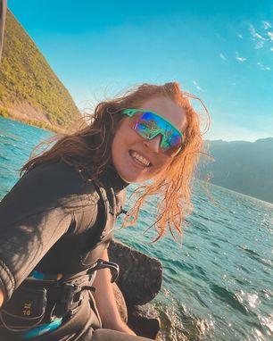 Sarah Jackson smiles in a wetsuit on a lake.