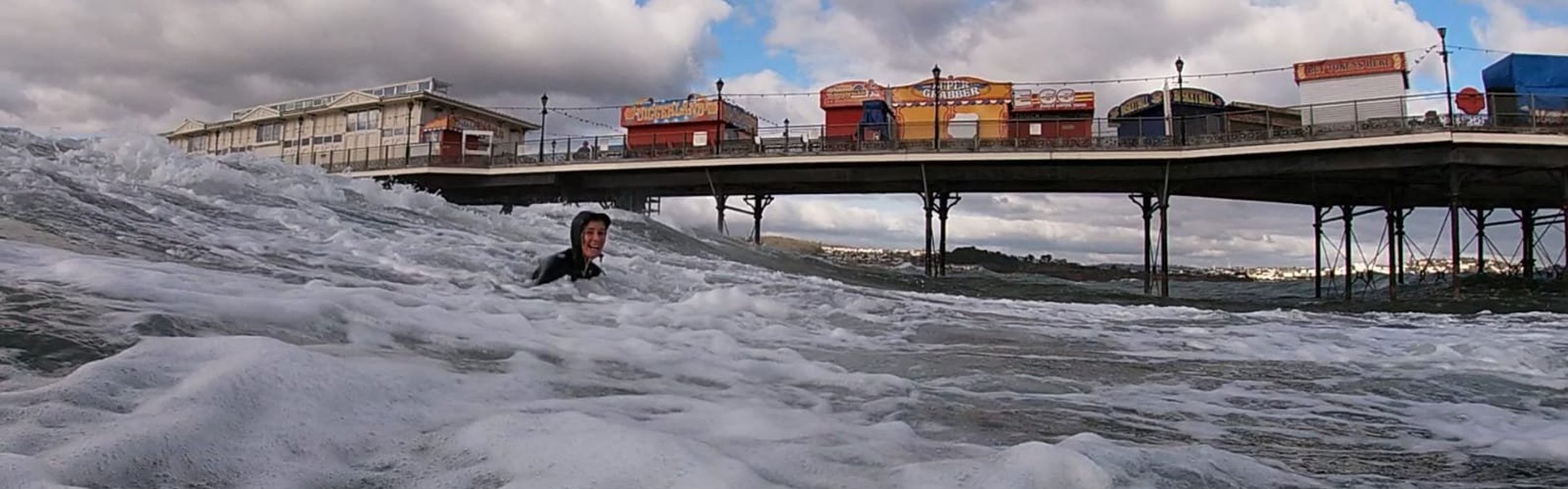 A fundraiser swimming for Marine Consevation Society. A pier can be seen behind her.