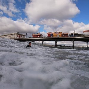 A fundraiser swimming for Marine Consevation Society. A pier can be seen behind her.