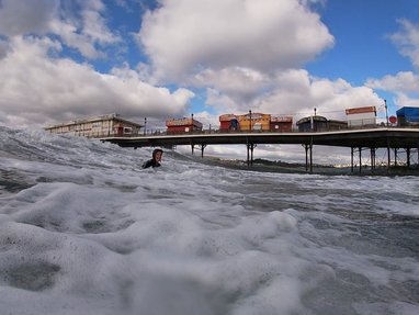 A fundraiser swimming for Marine Consevation Society. A pier can be seen behind her.