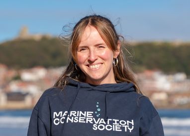 A landscape image of Marine Conservation Society staff member Lorna Donaghy, who is standing facing the camera wearing a dark blue Marine Conservation Society top
