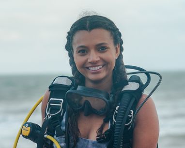 Inka Cresswell smiles at the camera wearing a diving buoyancy floatation device (BCD).