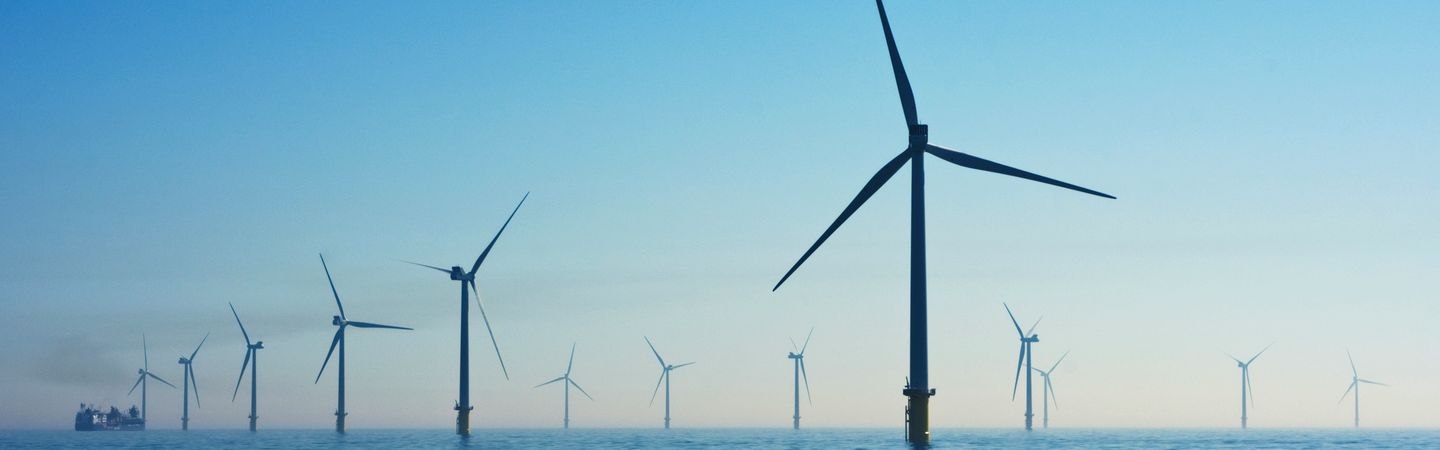 Wind turbines in water at Rampion Offshore Wind Farm, United Kingdom, with blue skies above the water
