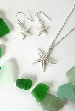 a handmade sterling silver starfish pendant and earring set from Beside the Sea Creations, designed to resemble real starfish.