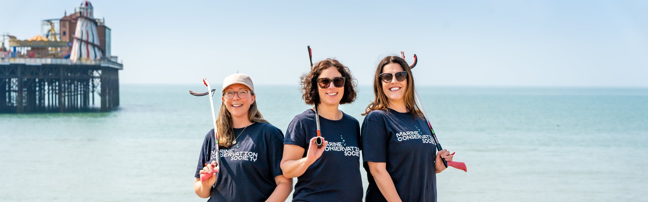 Marine Conservation Society's partnerships team posing together on a pebble beach