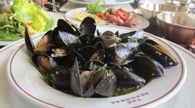 A bowl of mussels takes centre stage, surrounded by other seafood dishes