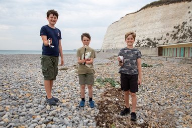 children actively collecting litter from a coastal area in the UK.
