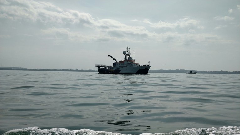 A small white fishing boat is photographed floating in the sea