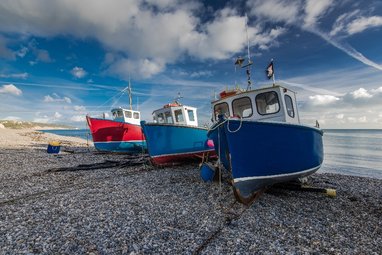 Boats resting on the beach of Beer, a small coastal village in Devon, England.