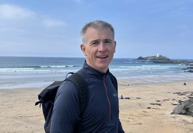 David Wilkin, the Marine Conservation Society's Treasurer, stands on a beach smiling at the camera