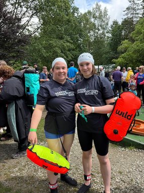 2 swimmers posing for a photo wearing MCS branded clothes